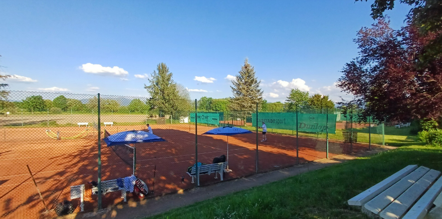 Weitblick über die Tennisanlage des TC March mit Sandplätzen und Sitzbereichen